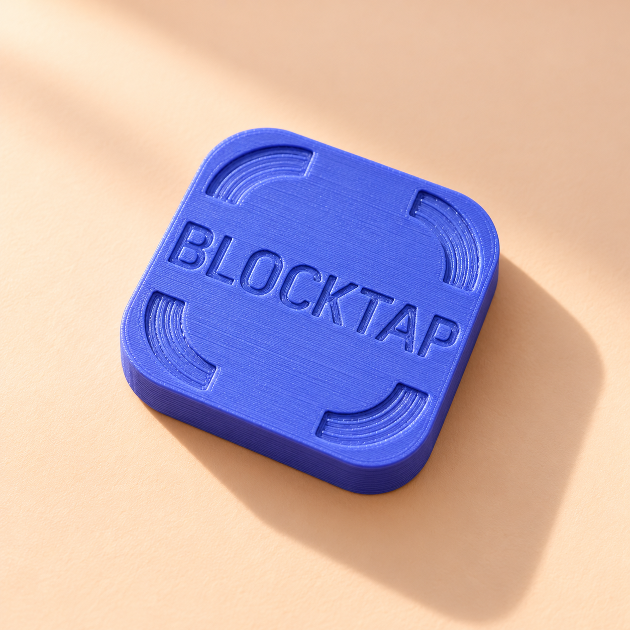 Violet Blocktap brick with engraved corners on a sunlit peach surface
